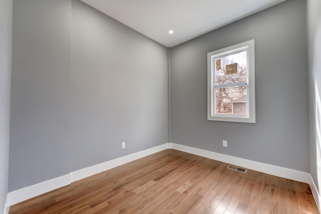 spare room with recessed lighting, visible vents, baseboards, and wood finished floors