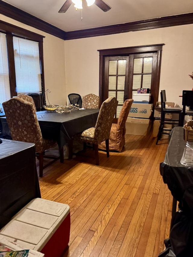 dining room featuring crown molding, light wood-style flooring, and a ceiling fan