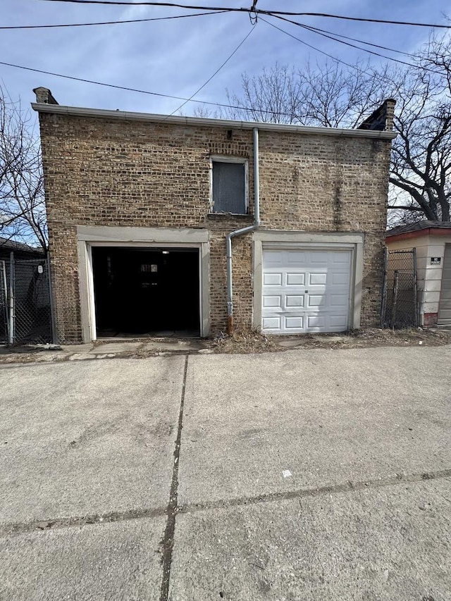 garage with fence and concrete driveway