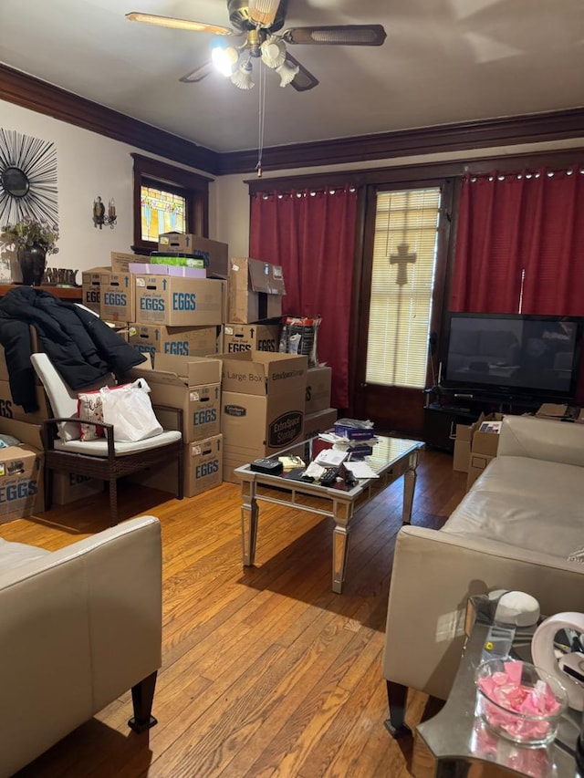 living room with light wood-style flooring, ornamental molding, and ceiling fan