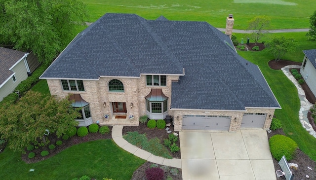1583 Pine Lake Dr, Naperville, IL 60564 - view of front facade featuring a shingled roof, concrete driveway, a chimney, a garage, and a front lawn