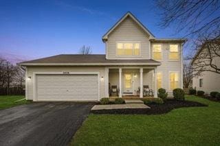 2428 Smithfield Ct, Aurora, IL 60503 - traditional-style house with covered porch, a garage, aphalt driveway, and a front lawn