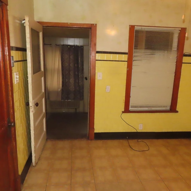 4938 W Wrightwood Ave, Chicago, IL 60639 - hall featuring tile walls, a wall mounted air conditioner, tile patterned floors, and wainscoting