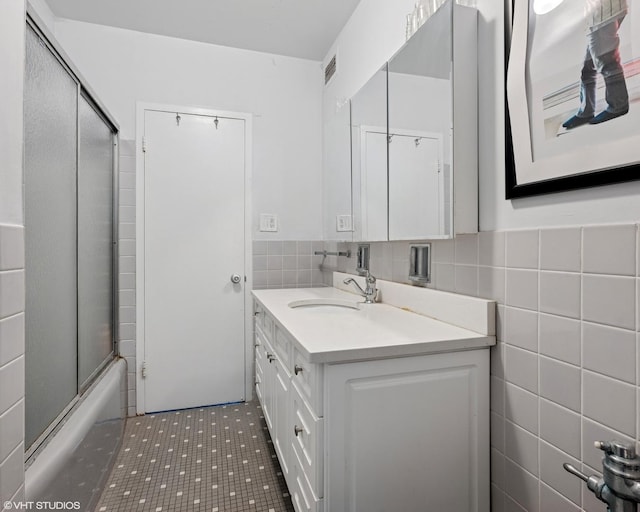 3180 N Lake Shore Dr Unit 15A, Chicago, IL 60657 - full bath featuring vanity, bath / shower combo with glass door, visible vents, and tile walls
