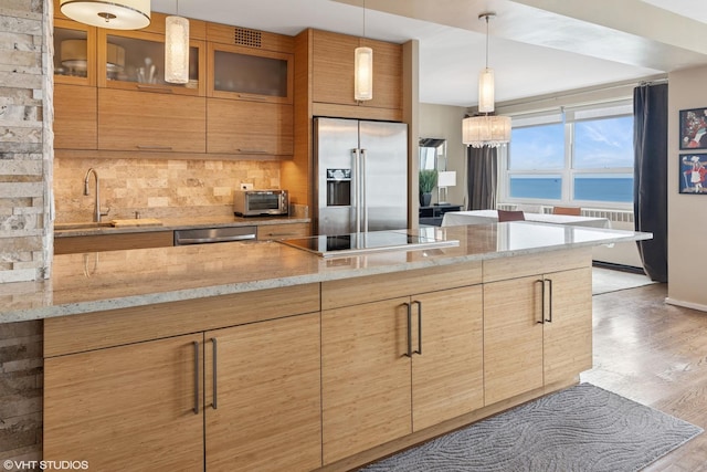 3180 N Lake Shore Dr Unit 15A, Chicago, IL 60657 - kitchen featuring light stone counters, light wood-style flooring, stainless steel appliances, tasteful backsplash, and glass insert cabinets