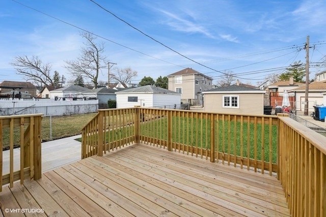 deck with a residential view, an outdoor structure, fence, and a yard