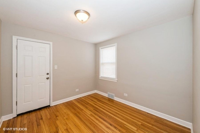 spare room featuring baseboards, visible vents, and light wood-style floors