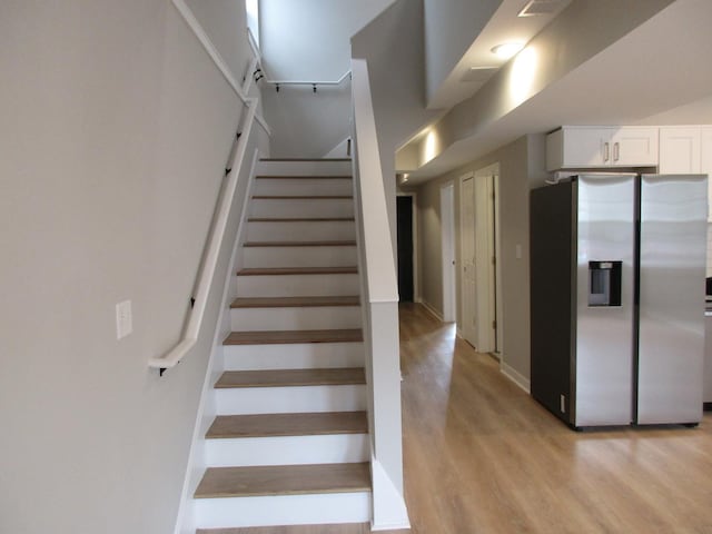 stairs with baseboards and wood finished floors