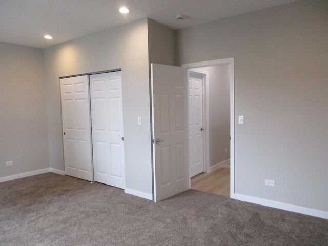 unfurnished bedroom featuring baseboards, a closet, recessed lighting, and light colored carpet