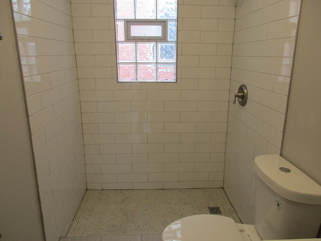 full bath with a tile shower and toilet