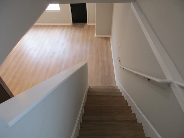 stairs with baseboards and wood finished floors