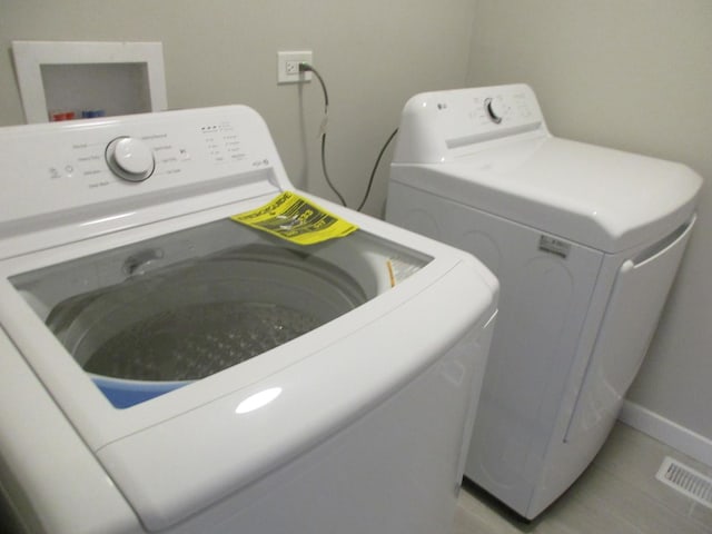 washroom with visible vents, laundry area, and washer and dryer