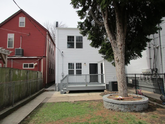 rear view of property featuring cooling unit, a fenced backyard, and a deck