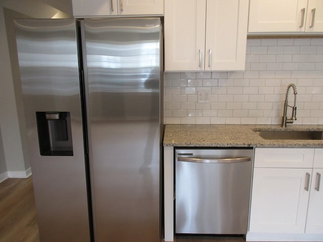 kitchen featuring white cabinets, a sink, stainless steel appliances, and tasteful backsplash