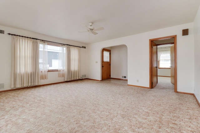 108 N Chatham St, Danvers, IL 61732 - empty room with baseboards, ceiling fan, arched walkways, and light colored carpet