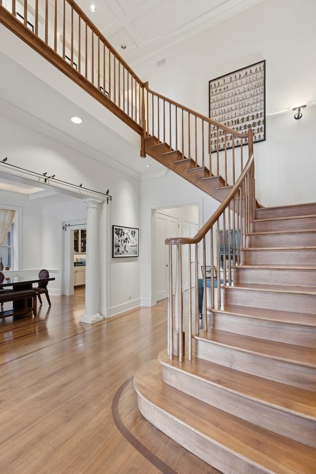 2735 N Dayton St, Chicago, IL 60614 - staircase featuring a high ceiling, crown molding, recessed lighting, wood finished floors, and decorative columns