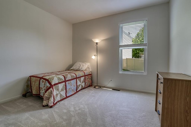 bedroom with light colored carpet and baseboards