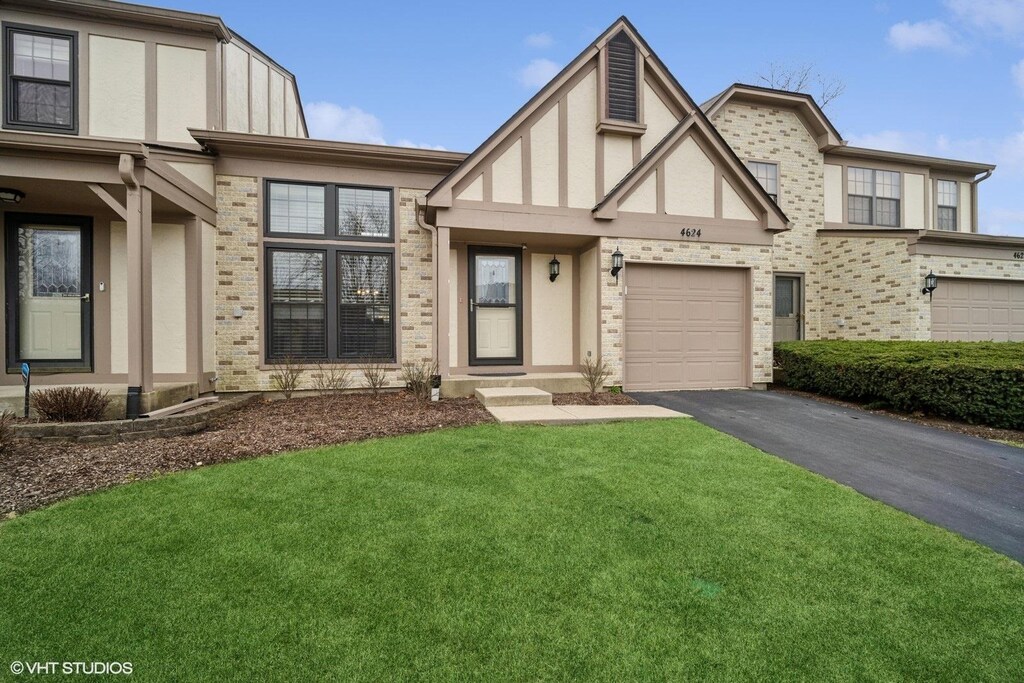 4624 Mumford Dr, Hoffman Estates, IL 60192 - tudor home featuring a front yard, stucco siding, brick siding, and aphalt driveway