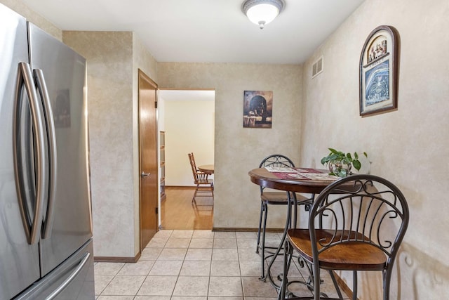 dining room featuring light tile patterned floors, visible vents, and baseboards