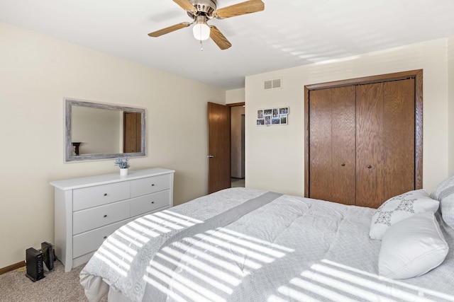 carpeted bedroom featuring visible vents, a closet, and ceiling fan