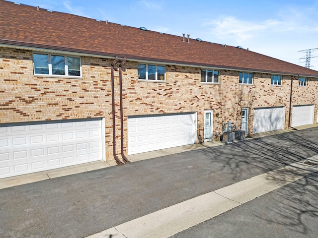 view of home's exterior featuring a shingled roof and brick siding