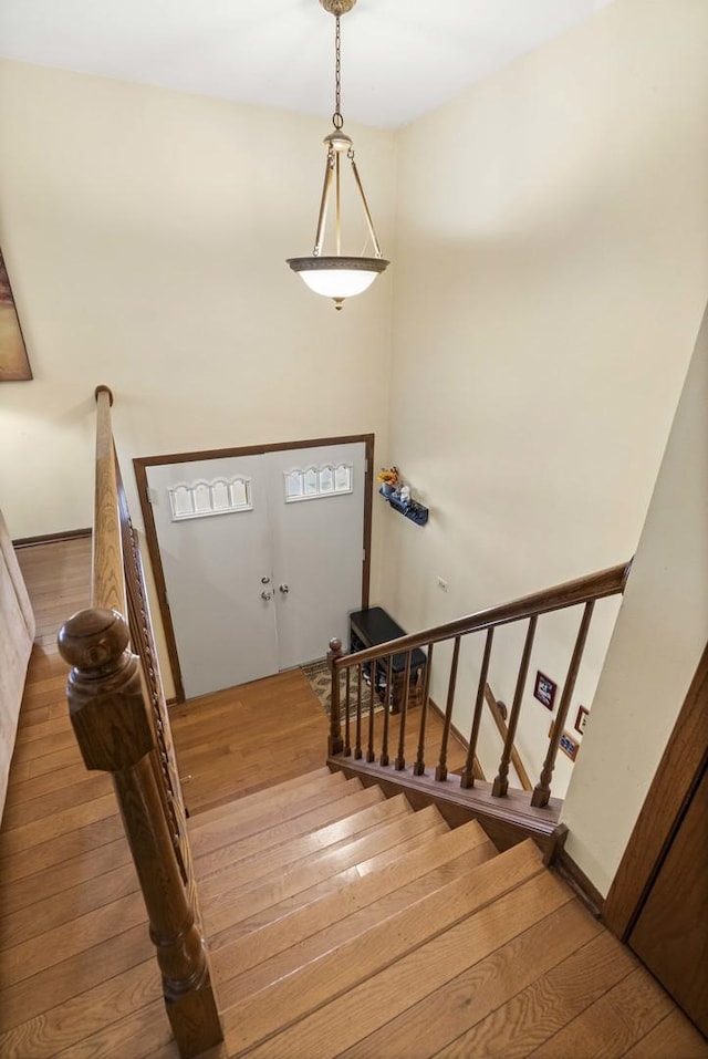 staircase featuring baseboards and hardwood / wood-style flooring