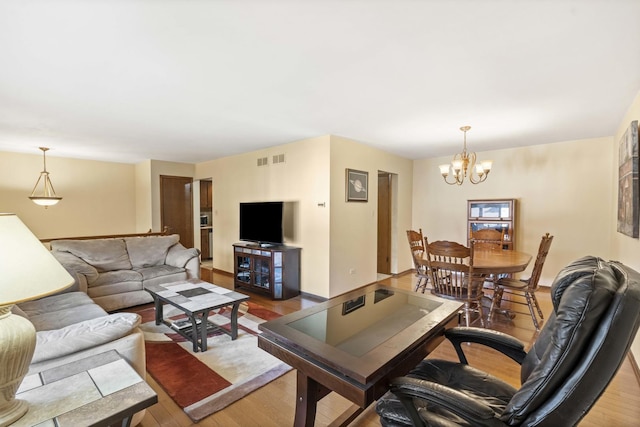 living room featuring a chandelier, wood finished floors, and visible vents