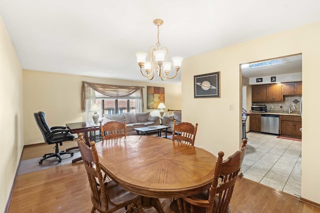 dining area featuring light wood-type flooring and an inviting chandelier