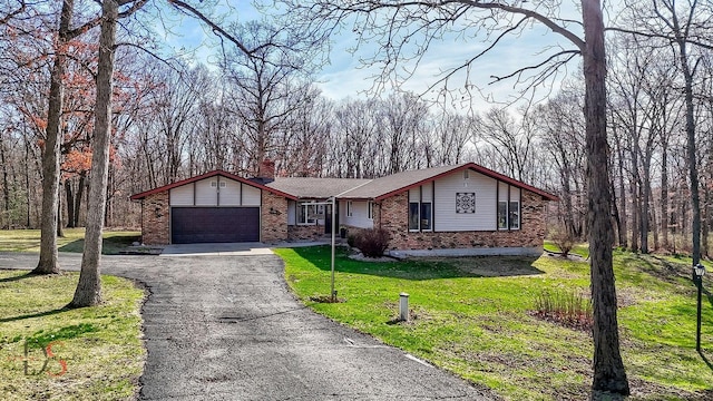 view of front of home featuring a front yard, a chimney, brick siding, aphalt driveway, and a garage