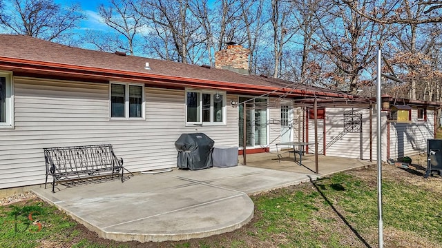 back of house with a patio and a chimney