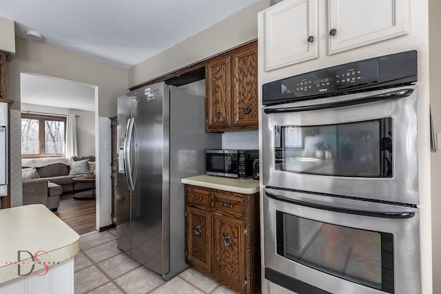kitchen featuring light countertops, backsplash, white cabinets, and appliances with stainless steel finishes