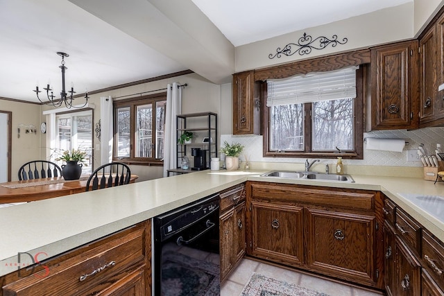 kitchen featuring light countertops, a sink, backsplash, dishwasher, and an inviting chandelier
