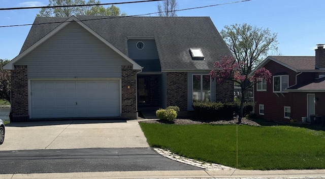 view of front of home featuring brick siding, a front yard, a garage, and concrete driveway