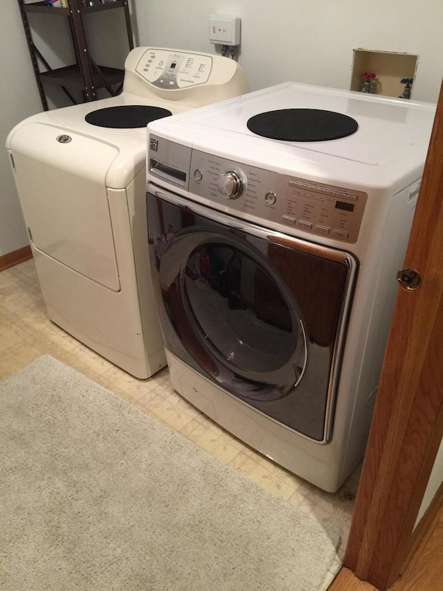 laundry room with separate washer and dryer, light floors, and laundry area