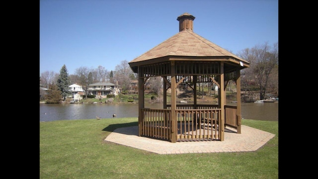 view of community with a lawn, a gazebo, and a water view
