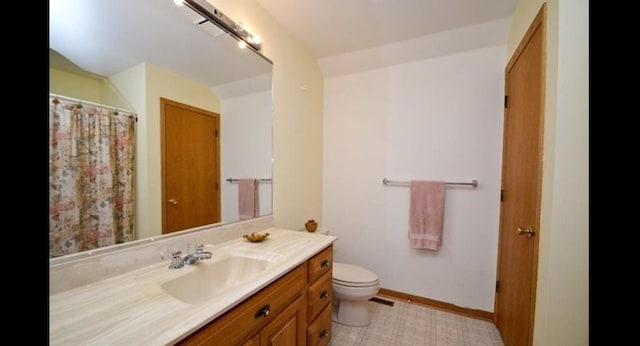 full bathroom featuring baseboards, vanity, and toilet