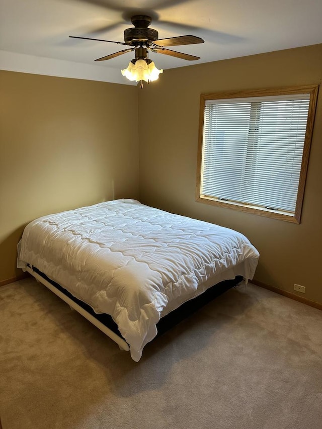 bedroom with ceiling fan, baseboards, and carpet flooring