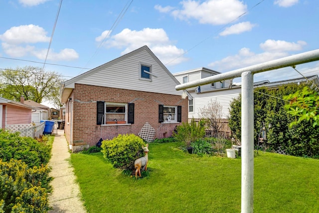 back of house with a yard and brick siding