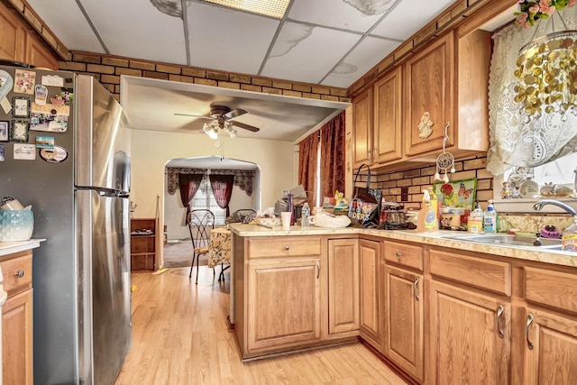 kitchen with freestanding refrigerator, a ceiling fan, and light countertops