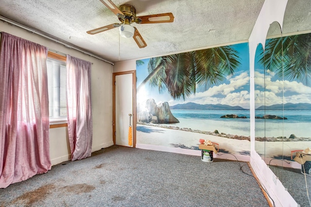 unfurnished bedroom featuring carpet floors, a water view, a textured ceiling, and ceiling fan