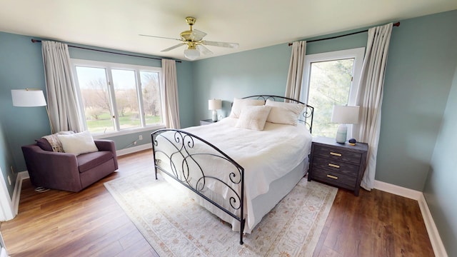 bedroom featuring baseboards, ceiling fan, and wood finished floors