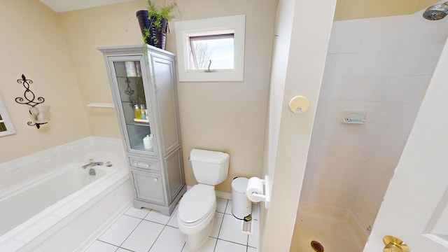 bathroom featuring tile patterned floors, toilet, a shower stall, and a garden tub