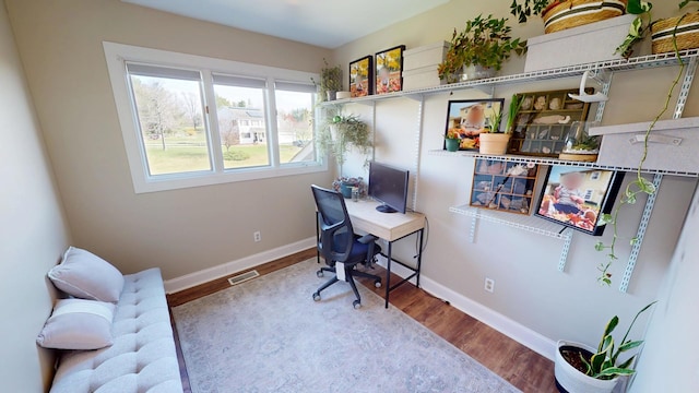 home office featuring visible vents, baseboards, and wood finished floors