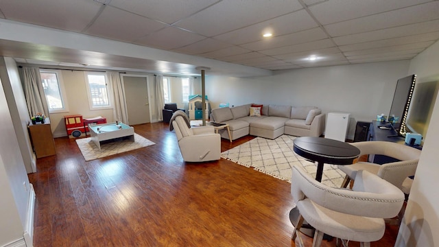 living room featuring a drop ceiling and wood finished floors