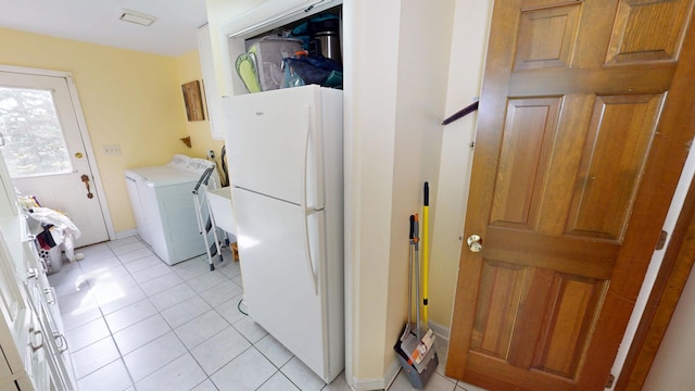 clothes washing area featuring cabinet space, washer / clothes dryer, and light tile patterned floors