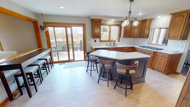 kitchen with brown cabinets, a kitchen island, a sink, and a kitchen breakfast bar