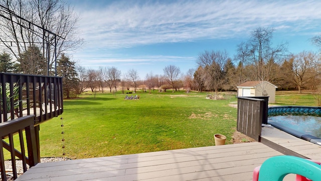 view of yard featuring a storage shed, a deck, and an outbuilding