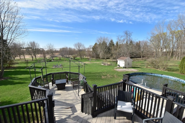 wooden terrace featuring a shed, a gazebo, an outbuilding, and a lawn