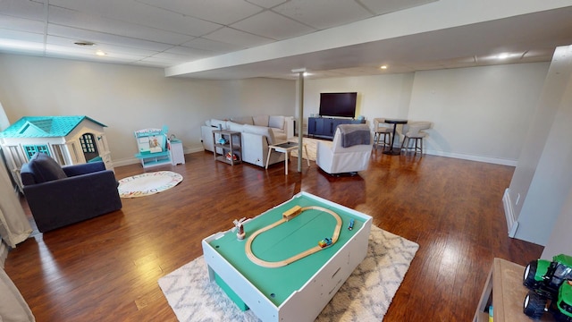 rec room with baseboards, a paneled ceiling, and wood finished floors