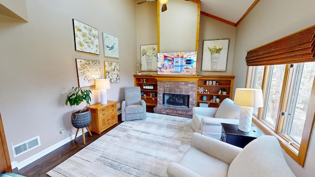 living area featuring a fireplace, dark wood finished floors, a ceiling fan, visible vents, and baseboards